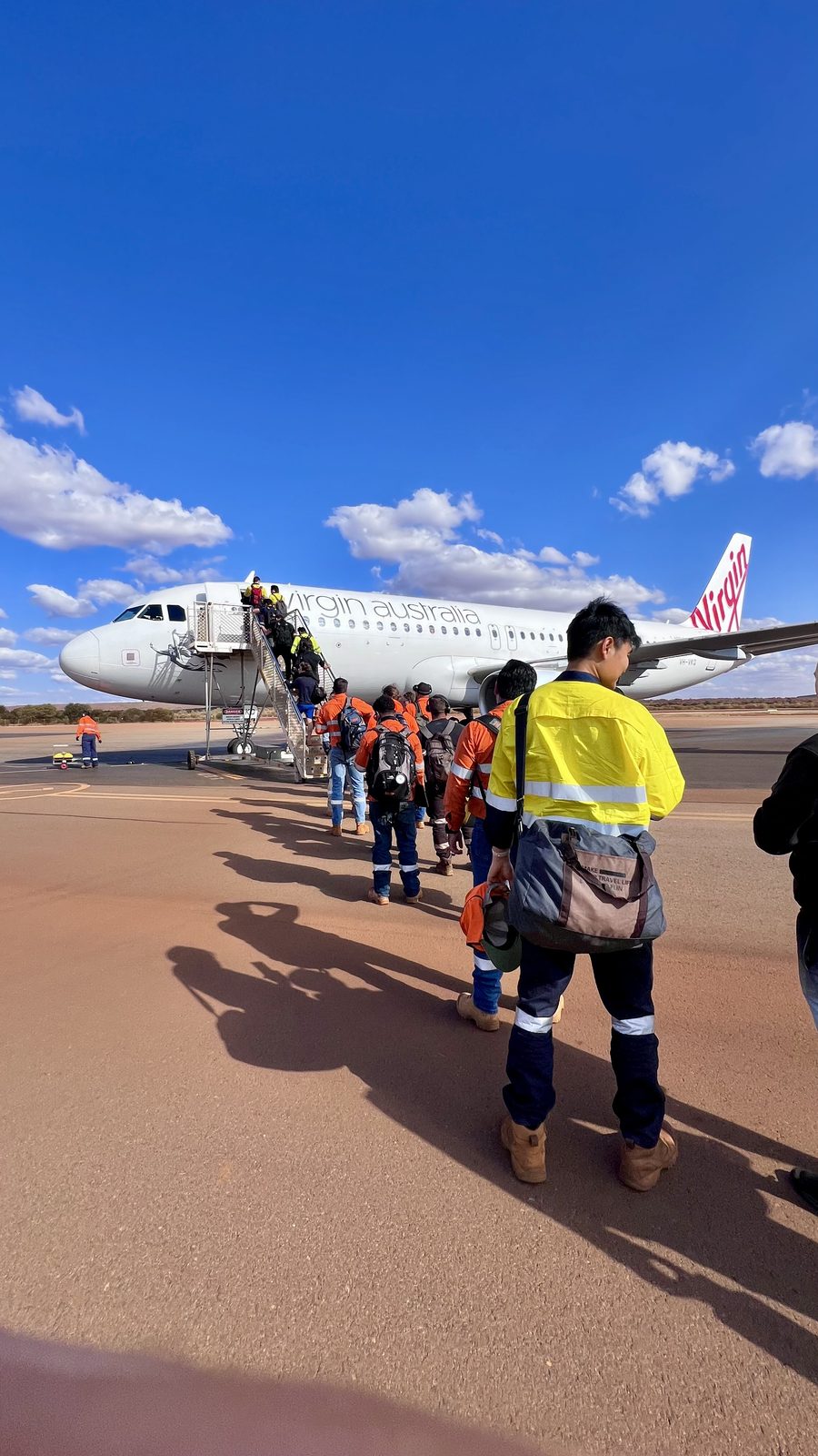 FIFO-werkers lopen naar het vliegtuig op een outback-vliegveld